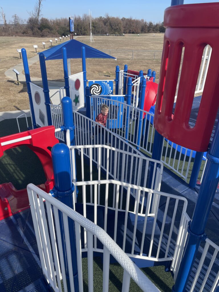 New playground layout. My son runs across a bridge on the play structure below as I look down on him from above because I can easily climb the stairs. 